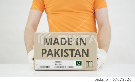 Carton with MADE IN PAKISTAN text being placed on the table 67675526