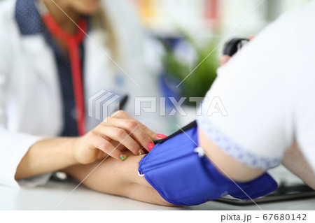 Woman doctor measures pressure to patient in medical office. 67680142