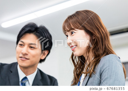 オフィスで相談しながらパソコンを操作する男女 オフィスで相談しながらパソコンを操作する男女 67681355