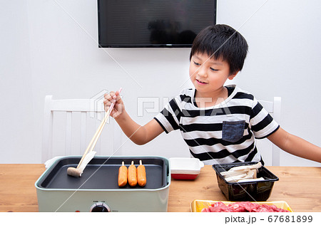 家で焼肉の準備をする小学生の男の子 家で焼肉の準備をする小学生の男の子 67681899