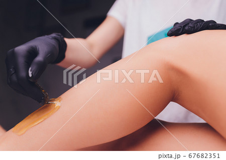Sugaring: epilation with liquate sugar at legs. Sugaring: epilation with liquate sugar at legs. 67682351