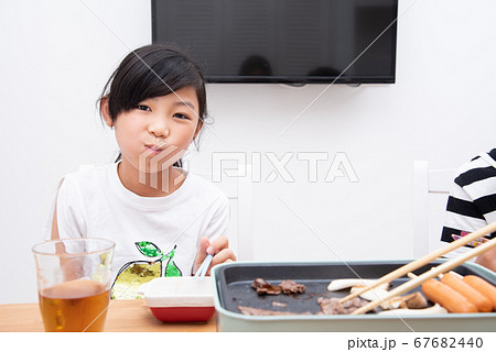 家で焼肉を食べる小学生の女の子 家で焼肉を食べる小学生の女の子 67682440