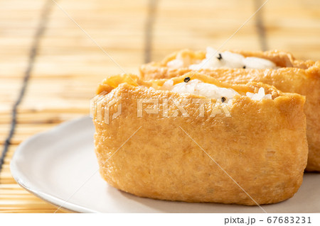 黒ごま入りのいなり寿司。背景、すだれ。 黒ごま入りのいなり寿司。背景、すだれ。 67683231