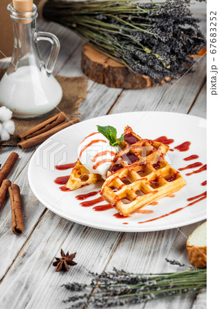 Belgian waffles poured with ice cream berry syrup 67683252