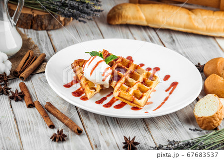 Belgian waffles poured with ice cream berry syrup Belgian waffles poured with ice cream berry syrup 67683537