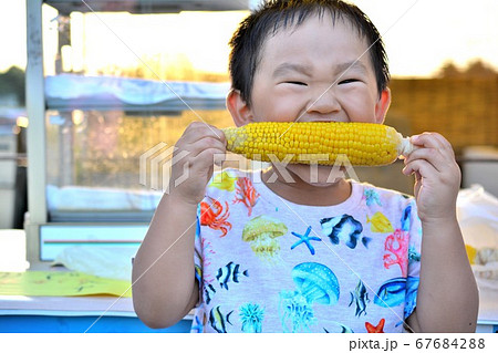 トウモロコシを食べる男の子 67684288
