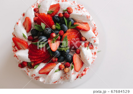 No bake strawberry cheesecake, decorated with sresh strawerries, mint and blueberry. Vegetarian food. Lactose free and gluten free. Top view No bake strawberry cheesecake, decorated with sresh strawerries, mint and blueberry. Vegetarian food. Lactose free and gluten free. Top view 67684529