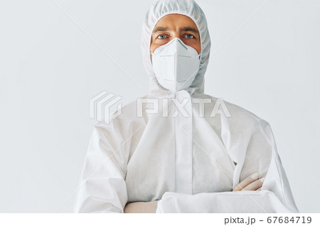 Confident doctor with crossed arms in protective medical suit with copy space Confident doctor with crossed arms in protective medical suit with copy space 67684719