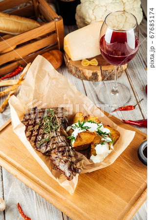 Cowboy beef steak with baked potato and sour cream Cowboy beef steak with baked potato and sour cream 67685174