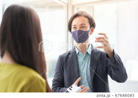 マスクをつけて職場で会話をする男女 マスクをつけて職場で会話をする男女 67686085