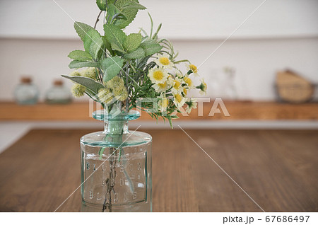 ダイニングテーブルに置かれたフェイクグリーンと造花 ダイニングテーブルに置かれたフェイクグリーンと造花 67686497