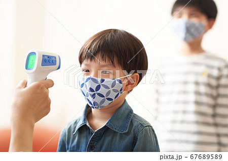 非接触体温計で体温測定をする男の子 非接触体温計で体温測定をする男の子 67689589