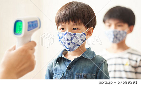 非接触温度計で検温をする男の子 67689591