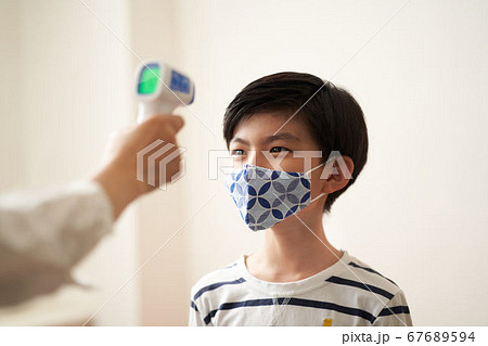 非接触体温計で検温をする男の子 非接触体温計で検温をする男の子 67689594