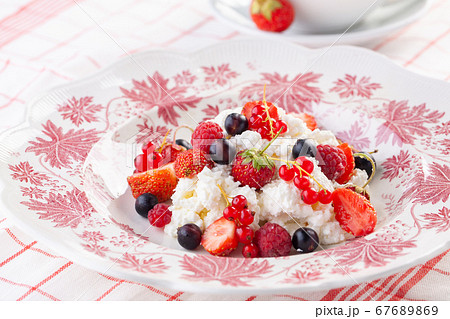 dessert with fresh berries on a red vintage plate. Farm cottage cheese dessert with fresh berries on a red vintage plate. Farm cottage cheese 67689869