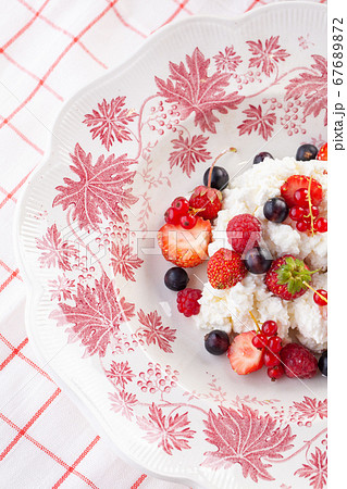 dessert with fresh berries on a red vintage plate. Farm cottage cheese dessert with fresh berries on a red vintage plate. Farm cottage cheese 67689872