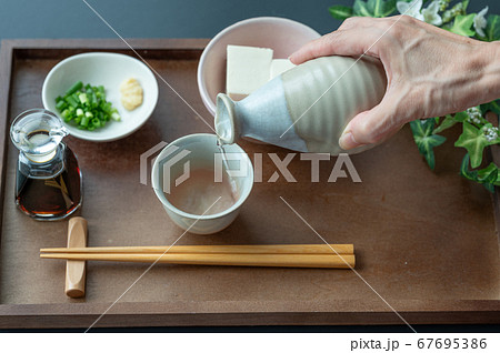 お猪口に日本酒を注ぐ お猪口に日本酒を注ぐ 67695386