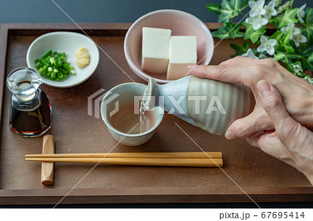 お猪口に日本酒を注ぐ お猪口に日本酒を注ぐ 67695414
