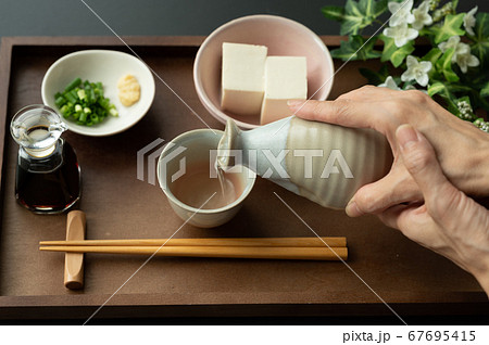 お猪口に日本酒を注ぐ お猪口に日本酒を注ぐ 67695415