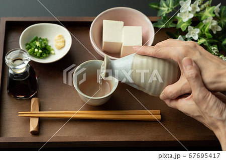 お猪口に日本酒を注ぐ お猪口に日本酒を注ぐ 67695417