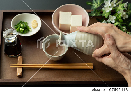 お猪口に日本酒を注ぐ お猪口に日本酒を注ぐ 67695418