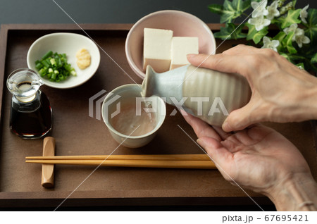 お猪口に日本酒を注ぐ お猪口に日本酒を注ぐ 67695421