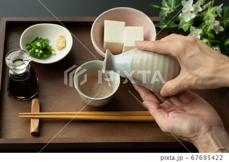 お猪口に日本酒を注ぐ お猪口に日本酒を注ぐ 67695422