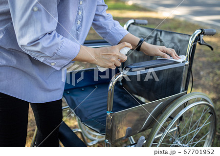 Hand of woman is spraying alcohol,disinfectant spray on wheelchair of old people,during the pandemic of Covid-19,Coronavirus,wipe cleaning,disinfecting wheelchair using spray alcohol after their use Hand of woman is spraying alcohol,disinfectant spray on wheelchair of old people,during the pandemic of Covid-19,Coronavirus,wipe cleaning,disinfecting wheelchair using spray alcohol after their use 67701952