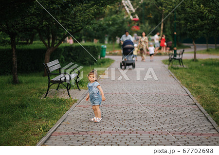 Happy little kid walking in park. Little girl in denim 67702698