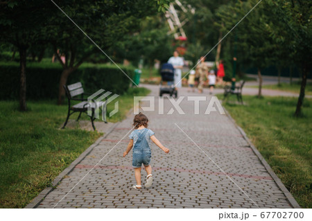Happy little kid walking in park. Little girl in denim 67702700