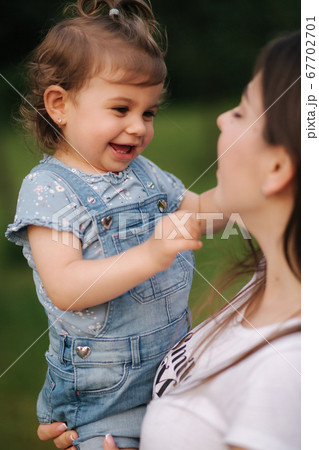 Beautiful little daughter Eighteen month old on mom's hands. Cute girl smile 67702701