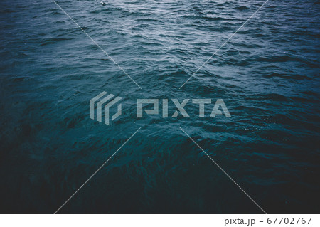 Blue sea surface, top view. Dark mood tone. 67702767