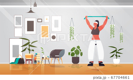 woman doing exercises with resistance band at home girl having workout fitness training healthy lifestyle woman doing exercises with resistance band at home girl having workout fitness training healthy lifestyle 67704661