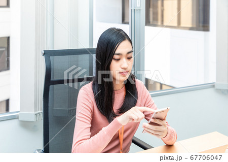 スマホを使う若い女性 ビジネス スマホを使う若い女性 ビジネス 67706047