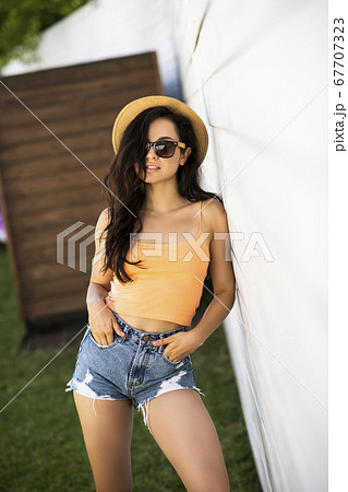 Pretty brunette girl in jeans shorts looking appealing Pretty brunette girl in jeans shorts looking appealing 67707323