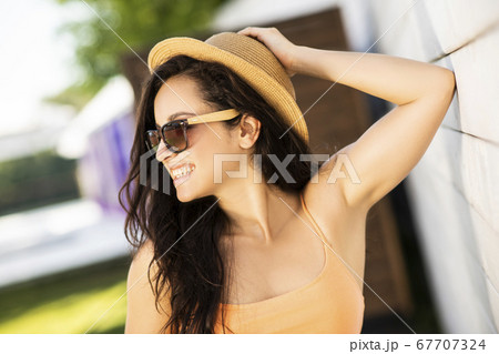 Pretty brunette girl in orange top smiling nicely Pretty brunette girl in orange top smiling nicely 67707324