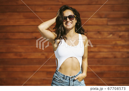 Beautiful brunette girl in eyeglasses touching her hair 67708573