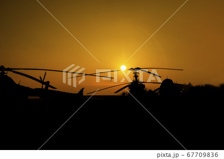 Silhouettes of Helicopters and Planes at the airport at Sunset 67709836