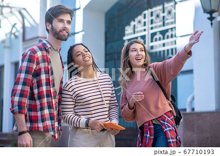 Tall guy and two girls standing on the street searching Tall guy and two girls standing on the street searching 67710193