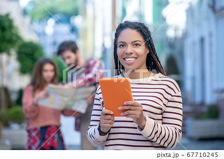 Young mulatto girl with a tablet on the street Young mulatto girl with a tablet on the street 67710245