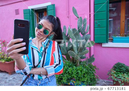 Happy young girl making pictures of herself Happy young girl making pictures of herself 67713181