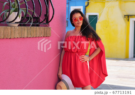 Beautiful young woman in red dress and sunglasses, 67713191