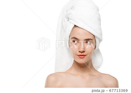 Beauty Day. Woman wearing towel doing her daily skincare routine isolated on white studio background Beauty Day. Woman wearing towel doing her daily skincare routine isolated on white studio background 67713369