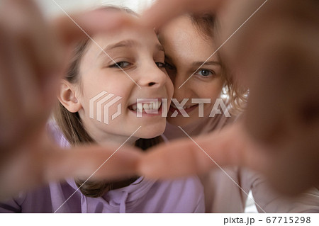 Close up happy mother and teenage daughter making heart gesture Close up happy mother and teenage daughter making heart gesture 67715298