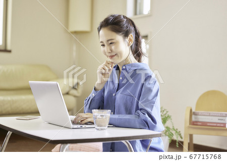 リビングでパソコンを使用する若い女性 リビングでパソコンを使用する若い女性 67715768