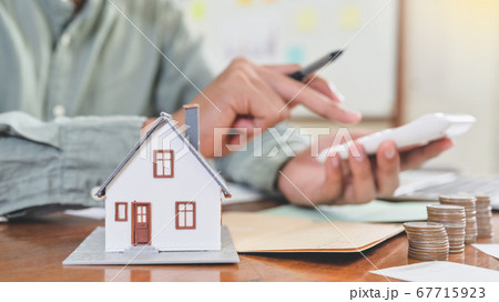 Model houses and coins with people using the Model houses and coins with people using the 67715923