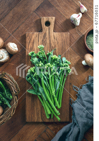 Broccolini fresh bunch on a rustic cutting board 67716031