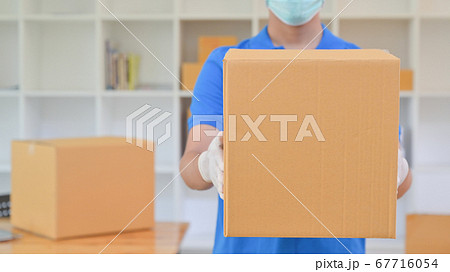 The delivery staff held a brown paper box. He was The delivery staff held a brown paper box. He was 67716054