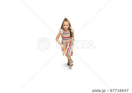 Happy little caucasian girl jumping and running isolated on white background Happy little caucasian girl jumping and running isolated on white background 67716647
