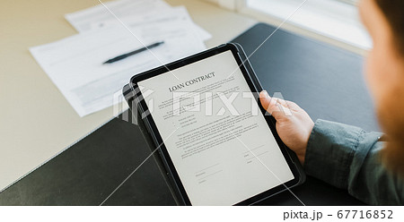 Businessman signing loan contract on tablet. Businessman signing loan contract on tablet. 67716852